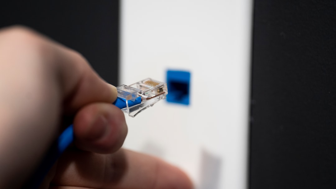 Ethernet cable being connected to network equipment, representing business computer networking. Photo by 2H Media on Unsplash.