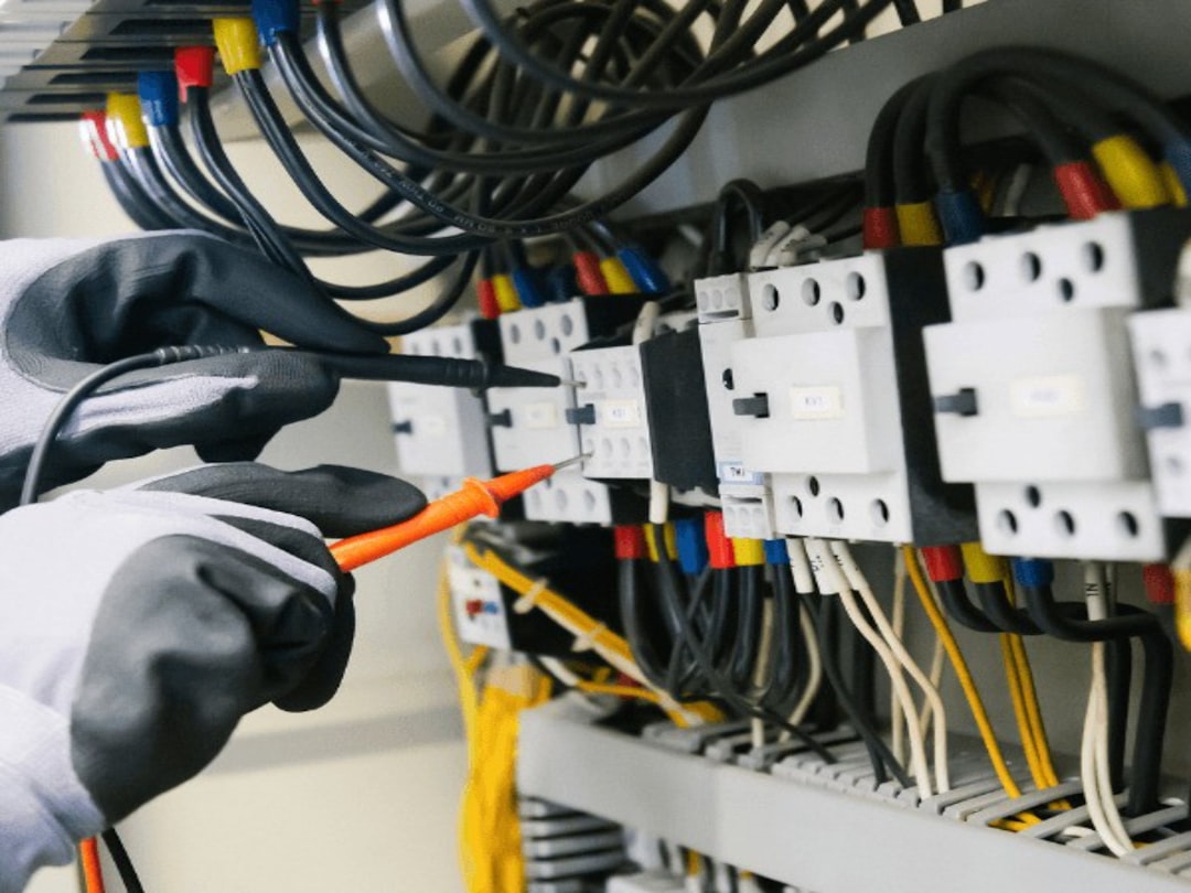 Electrician testing wiring in an electrical panel, representing electrician marketing. Photo by Toolmash Expo on Unsplash.