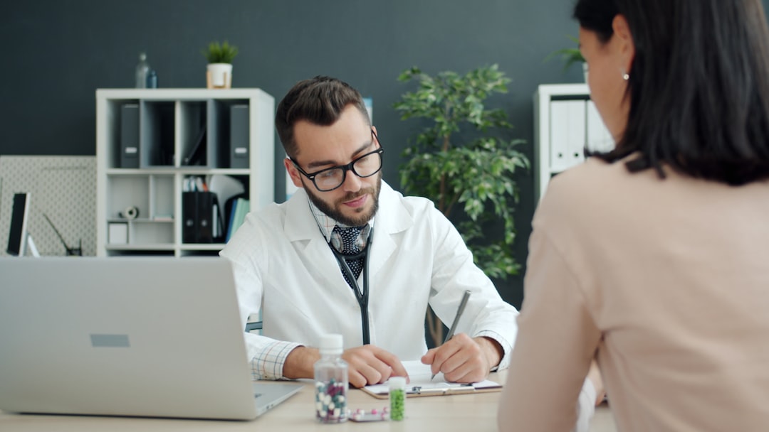 Doctor consulting with a patient in a modern medical clinic, representing medical practice marketing. Photo by Vitaly Gariev on Unsplash.