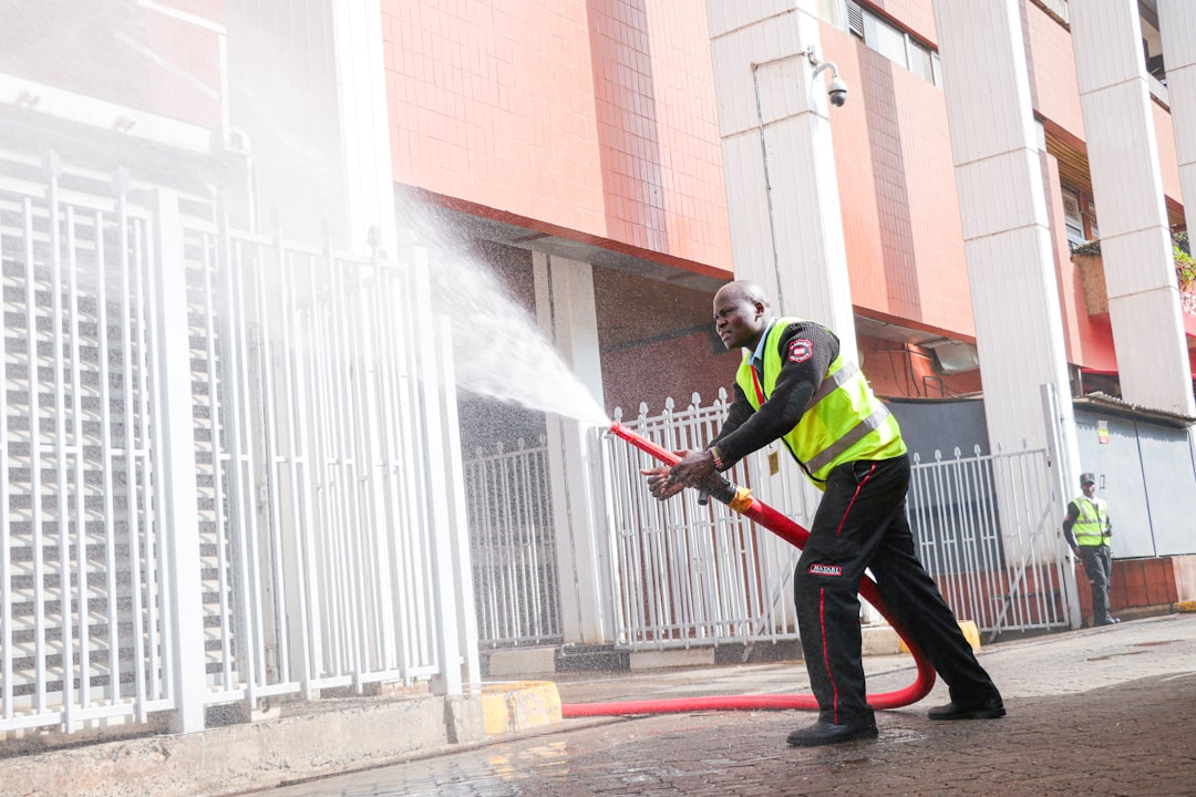 Worker using high-pressure exterior cleaning equipment, representing pressure washing marketing. Photo by Brian Kungu on Unsplash.
