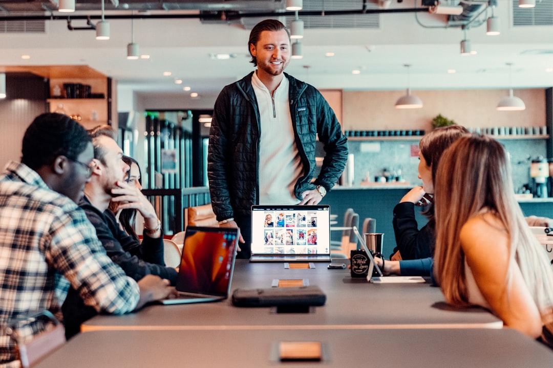 Digital marketing team collaborating around laptops in a professional office. Photo by Chase Chappell on Unsplash.
