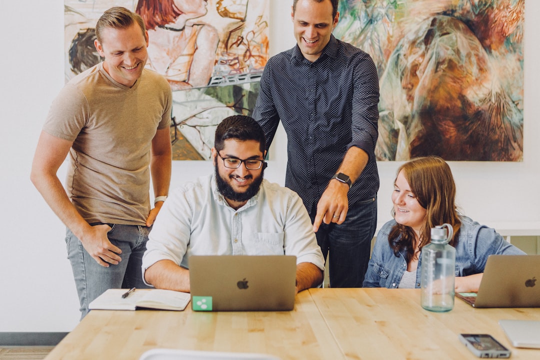 Business team reviewing digital strategy together in a modern office. Photo by Jud Mackrill on Unsplash.