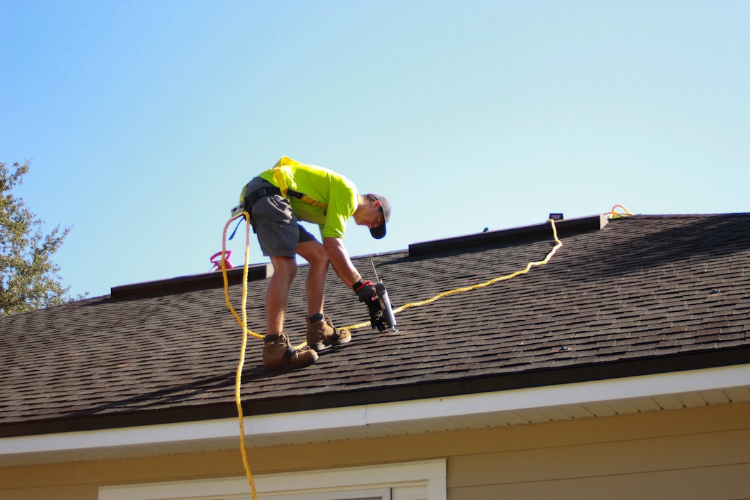 Roofer working on a residential roof, representing roofing company marketing. Photo by Raze Solar on Unsplash.